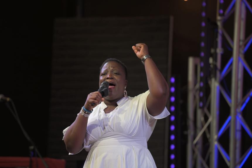 A worshipper lifting her hands in praise at KEMIF